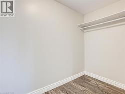 Interior closet space featuring white walls and wood-finish flooring -