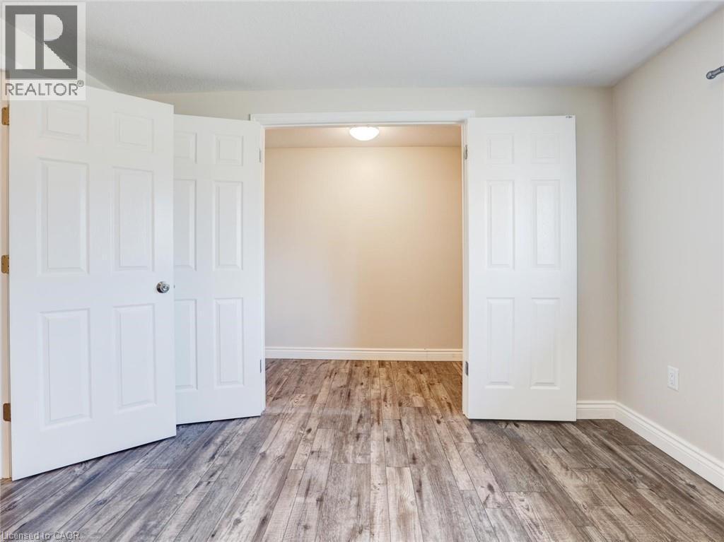 Double interior doors opening to a separate room, featuring wood-finish flooring - 833 Doon Village Road, Kitchener, ON - Indoor Photo Showing Other Room