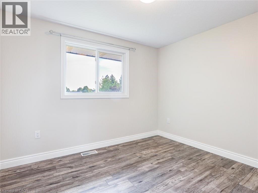 Room featuring wood-finish flooring, white baseboards, and neutral wall tones - 833 Doon Village Road, Kitchener, ON - Indoor Photo Showing Other Room