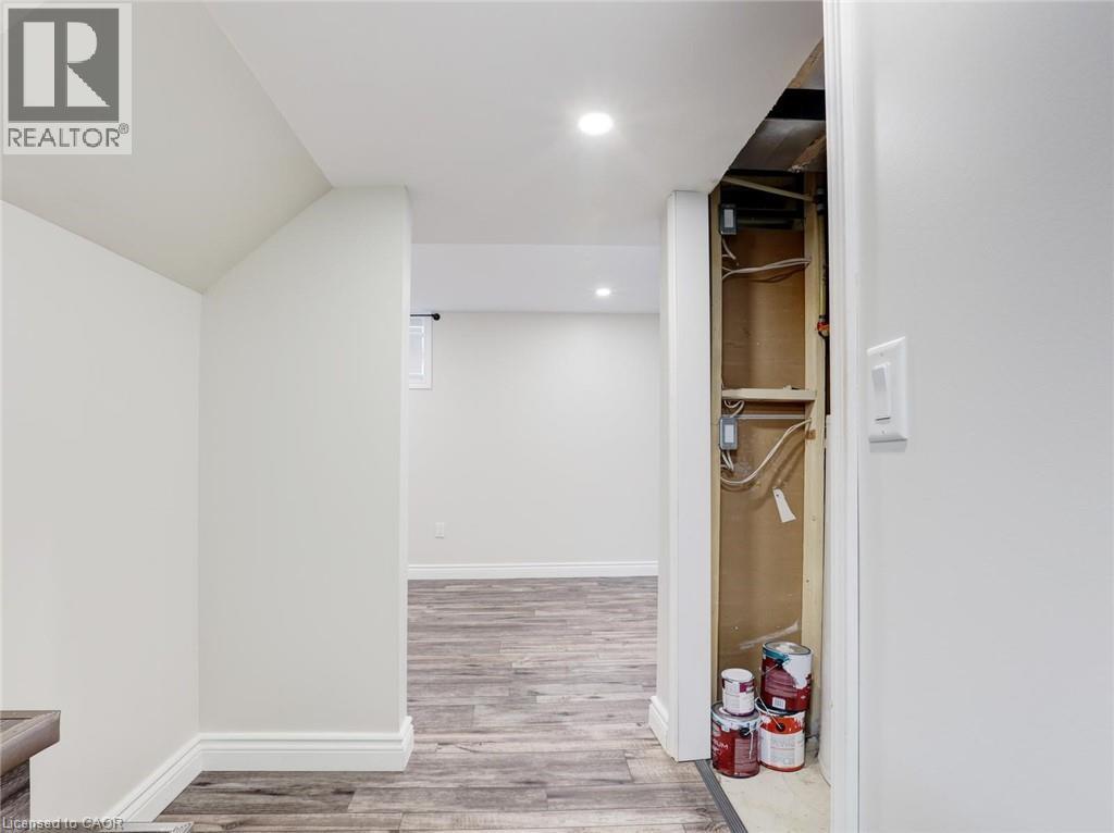 Wood-finish flooring throughout, complemented by crisp white walls and recessed ceiling lighting - 833 Doon Village Road, Kitchener, ON - Indoor Photo Showing Other Room