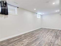 Spacious room featuring light gray wood-finish flooring, white walls, and recessed ceiling lighting -