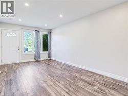 Spacious room featuring wood-finish flooring, recessed lighting, and expansive windows -