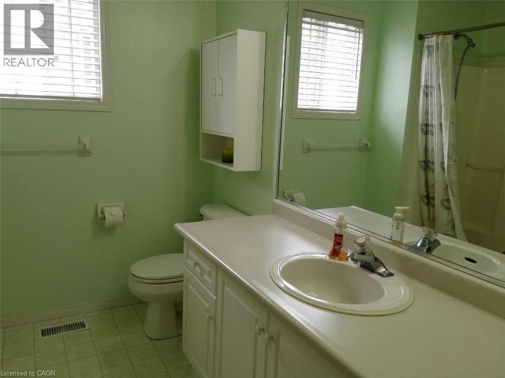 Bathroom featuring a single basin vanity with an oval sink, an integrated countertop, and white cabinetry - 350 Havendale Crescent, Waterloo, ON - Indoor Photo Showing Bathroom