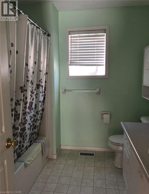 Bathroom featuring a built-in bathtub with shower, toilet, and vanity with countertop - 350 Havendale Crescent, Waterloo, ON - Indoor Photo Showing Bathroom