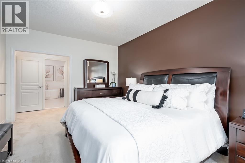 Carpeted room with a dark accent wall, two-panel interior doors, and a ceiling-mounted light fixture - 4285 Couples Crescent, Burlington, ON - Indoor Photo Showing Bedroom
