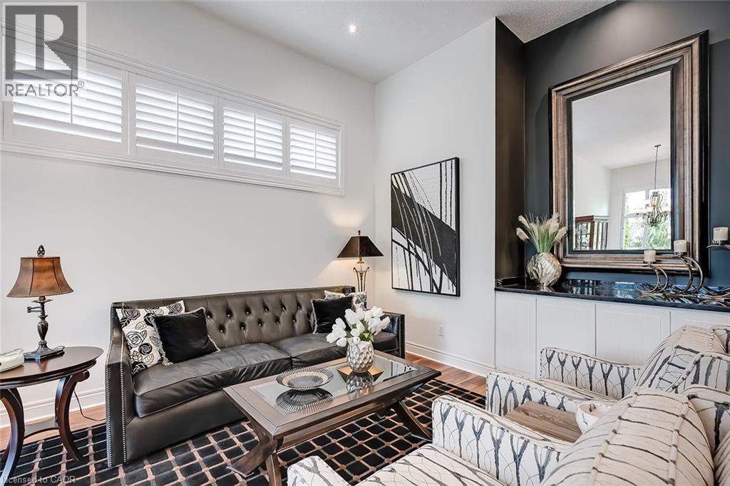 Living area featuring wood-finish flooring and a distinctive dark accent wall - 4285 Couples Crescent, Burlington, ON - Indoor Photo Showing Other Room