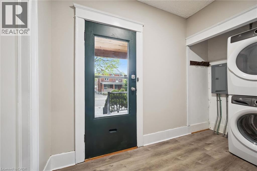 Neutral wall paint, wood-finish flooring, and white trim work - 15 Gordon Avenue, Kitchener, ON - Indoor Photo Showing Laundry Room