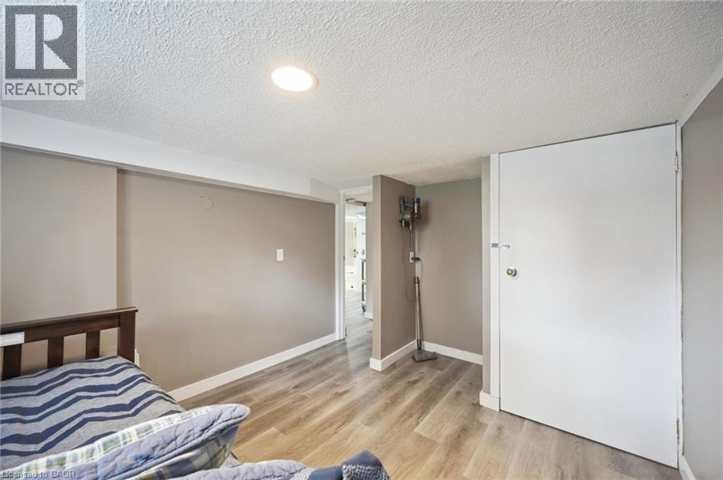 Recessed lighting illuminates this room featuring wood-finish flooring, neutral wall tones, and white trim - 15 Gordon Avenue, Kitchener, ON - Indoor Photo Showing Bedroom