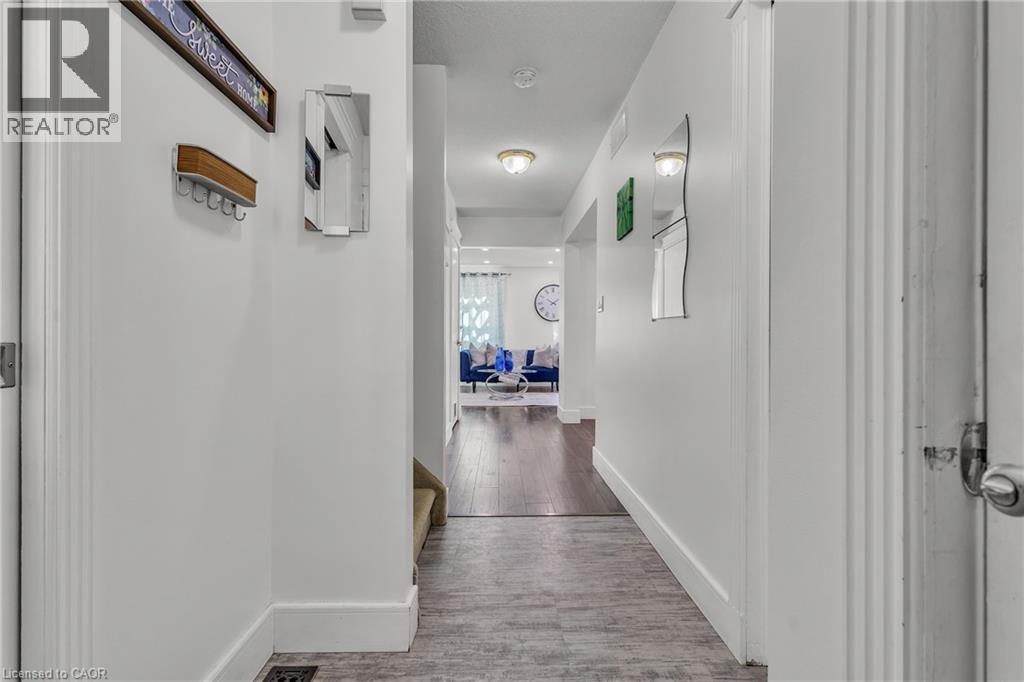 Hallway featuring wood-finish flooring transitioning to a darker wood-finish, white walls, and recessed lighting - 425 Erinbrook Drive, Kitchener, ON - Indoor Photo Showing Other Room