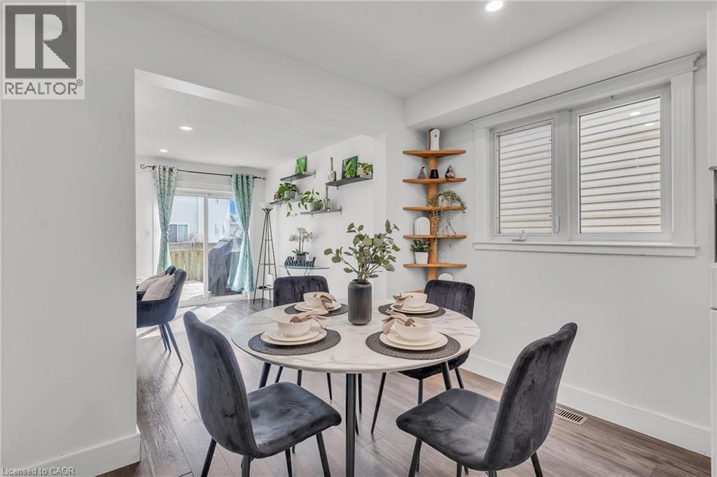 Dining area featuring wood-finish flooring, a double window with horizontal blinds, built-in corner shelving, and recessed lighting - 425 Erinbrook Drive, Kitchener, ON - Indoor Photo Showing Dining Room