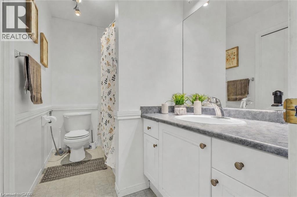 White vanity with a grey countertop, integrated sink, and chrome faucet - 425 Erinbrook Drive, Kitchener, ON - Indoor Photo Showing Bathroom