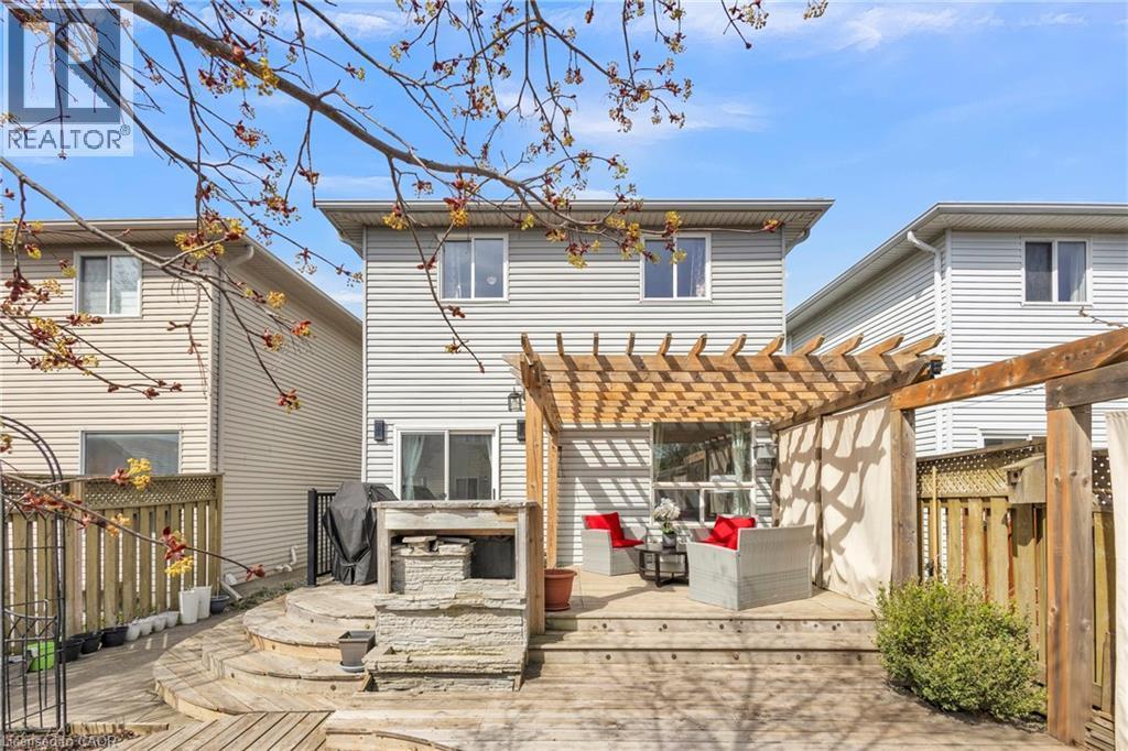 Multi-level wood deck featuring a pergola, privacy curtains, and a built-in stone outdoor kitchen structure - 425 Erinbrook Drive, Kitchener, ON - Outdoor With Deck Patio Veranda With Exterior