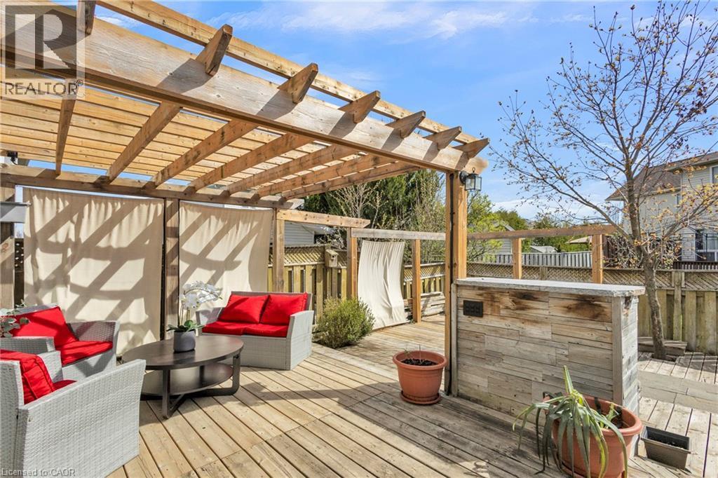Expansive wood deck with a built-in pergola, privacy screens, and a stone-clad outdoor bar - 425 Erinbrook Drive, Kitchener, ON - Outdoor With Deck Patio Veranda