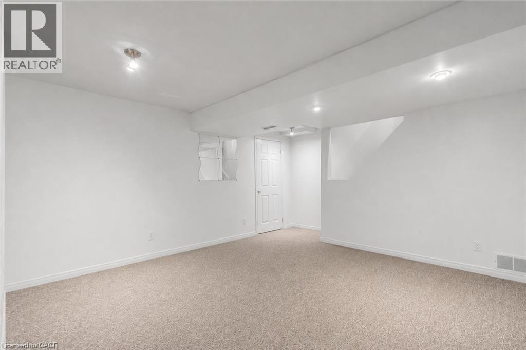 Spacious room featuring light-toned carpet flooring, white painted walls, and recessed lighting - 425 Erinbrook Drive, Kitchener, ON - Indoor Photo Showing Other Room