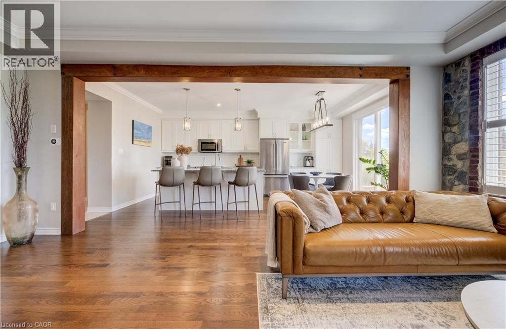 Open-concept living area featuring rich wood-finish flooring, exposed wood beams, and a stone accent wall - 19 Shoreacres Drive, Kitchener, ON - Indoor Photo Showing Living Room