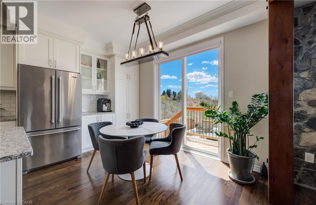 Kitchen dining area featuring wood-finish flooring and a contemporary chandelier - 19 Shoreacres Drive, Kitchener, ON - Indoor