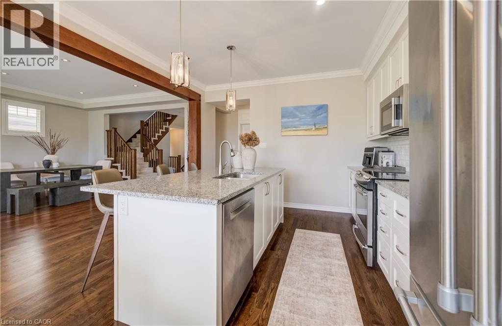 Kitchen featuring a central island with granite countertop, stainless steel appliances, white cabinetry, and wood-finish flooring - 19 Shoreacres Drive, Kitchener, ON - Indoor Photo Showing Kitchen With Stainless Steel Kitchen With Upgraded Kitchen