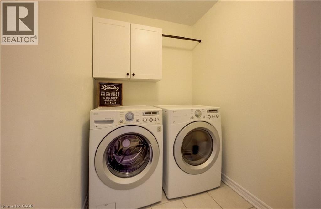 Dedicated laundry area featuring tile flooring, upper cabinetry, and a clothing rod - 19 Shoreacres Drive, Kitchener, ON - Indoor Photo Showing Laundry Room