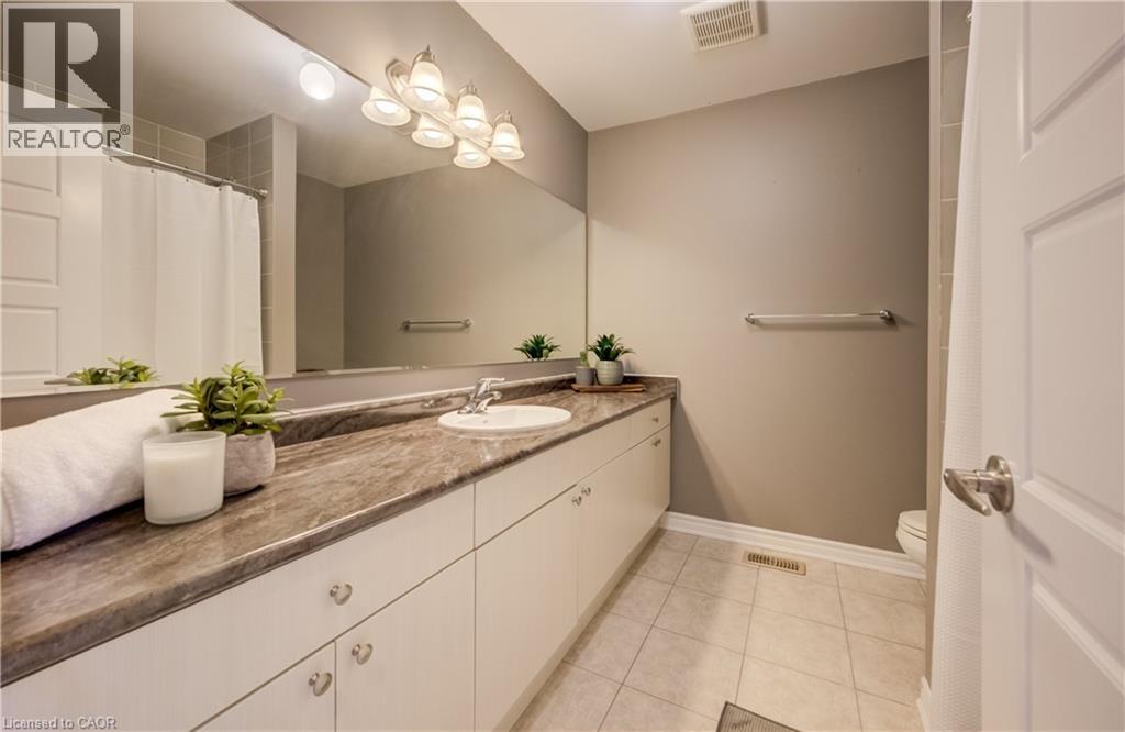 Bathroom featuring an extended vanity with a stone-finish countertop and an integrated sink - 19 Shoreacres Drive, Kitchener, ON - Indoor Photo Showing Bathroom