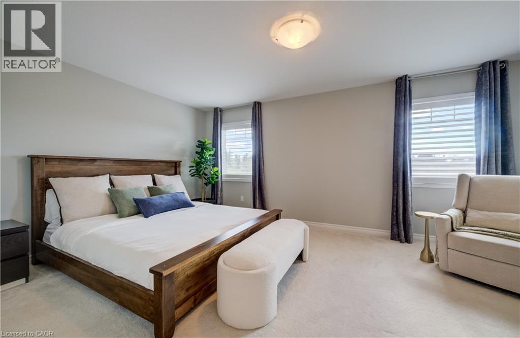 Bedroom featuring light gray wall paint, two windows with blinds and curtains, a ceiling-mounted light fixture, and carpeted flooring - 19 Shoreacres Drive, Kitchener, ON - Indoor Photo Showing Bedroom