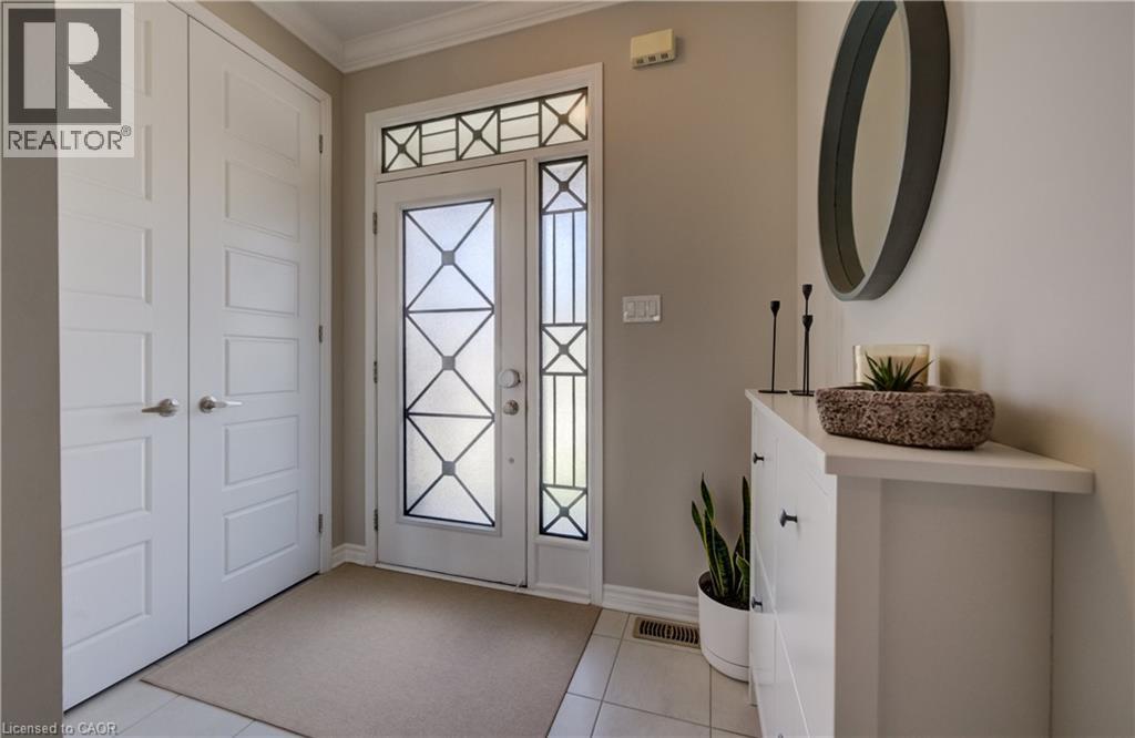Entryway featuring tiled flooring, a decorative glass front door with sidelight and transom, and a built-in storage cabinet - 19 Shoreacres Drive, Kitchener, ON - Indoor Photo Showing Other Room