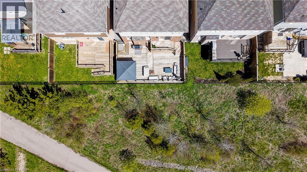 Expansive backyard featuring a large wooden deck, a covered patio area, and a lush green lawn - 19 Shoreacres Drive, Kitchener, ON - Outdoor