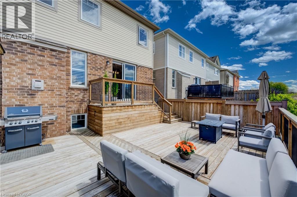 Multi-level wood deck featuring wood railings with black balusters, a privacy fence, and direct access to the interior via a sliding glass door - 19 Shoreacres Drive, Kitchener, ON - Outdoor With Deck Patio Veranda With Exterior