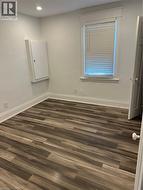Unfurnished room with dark hardwood / wood-style flooring -