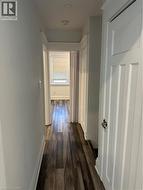 Hall with dark hardwood / wood-style floors -