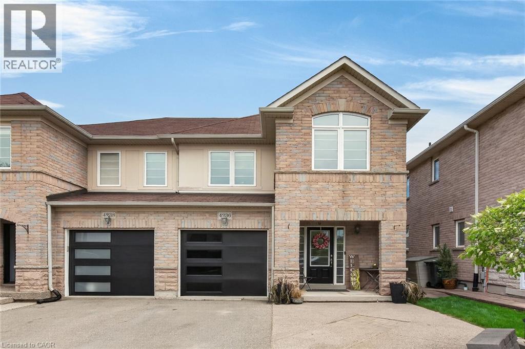 Stone and stucco facade featuring a prominent gable, arched window, two distinct garage doors with horizontal glass panels, and a covered entry - 4236 Prudham Avenue, Burlington, ON - Outdoor With Facade
