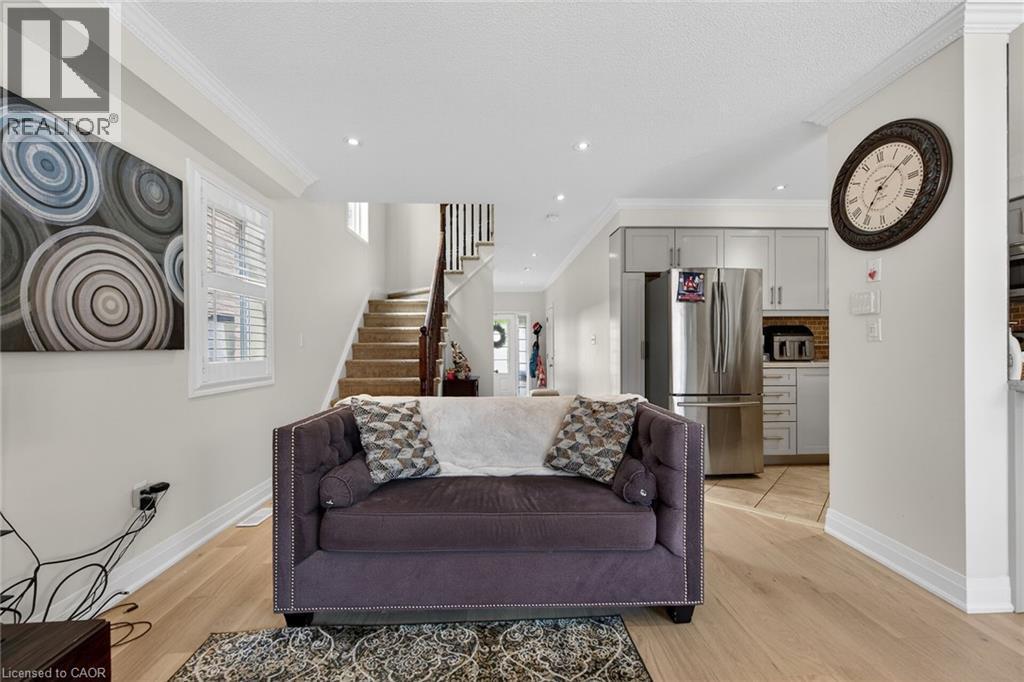 Bright open-concept living space with light wood-finish flooring, recessed lighting, crown molding, and plantation shutters - 4236 Prudham Avenue, Burlington, ON - Indoor Photo Showing Other Room