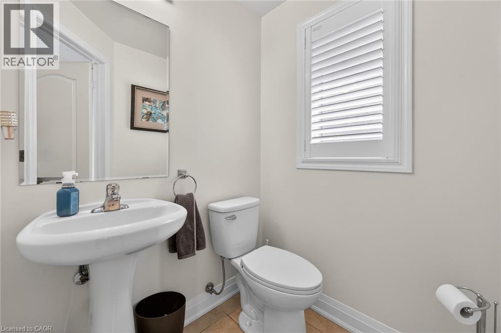 Pedestal sink with chrome faucet, toilet, and window with white louvered blinds - 4236 Prudham Avenue, Burlington, ON - Indoor Photo Showing Bathroom