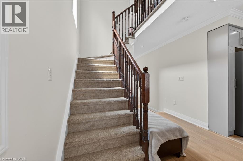Carpeted staircase with dark wood newel posts and balusters - 4236 Prudham Avenue, Burlington, ON - Indoor Photo Showing Other Room