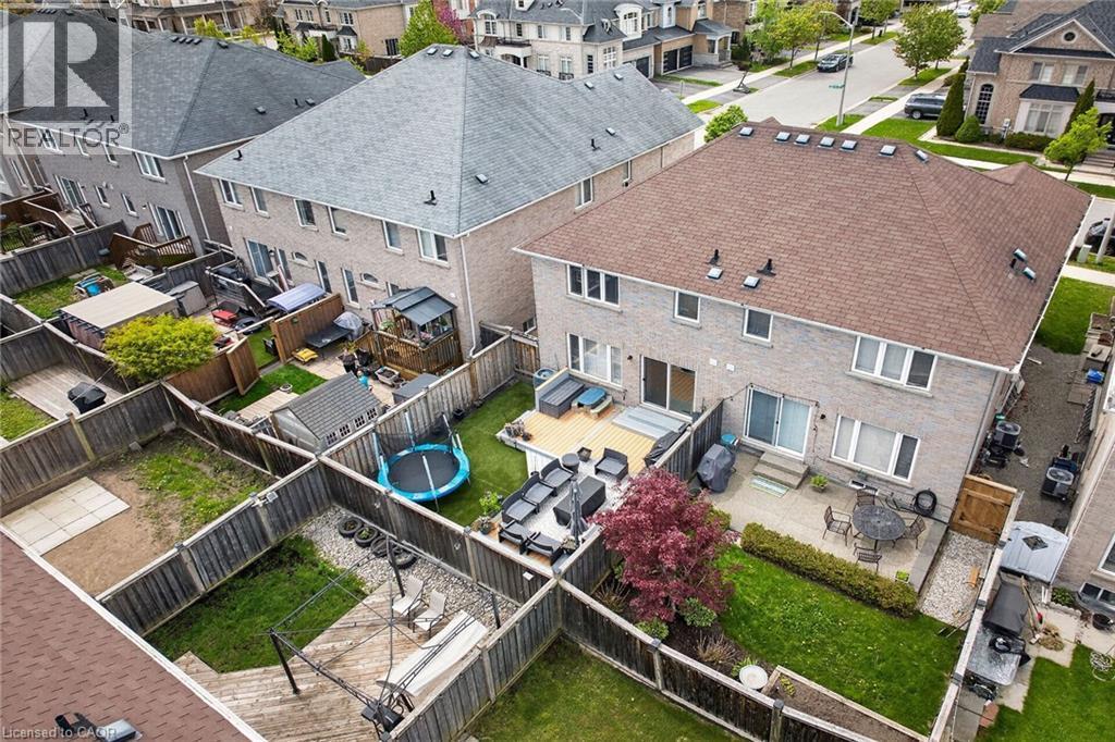 Expansive backyard featuring a multi-level deck, a concrete patio, and a manicured lawn - 4236 Prudham Avenue, Burlington, ON - Outdoor With Deck Patio Veranda