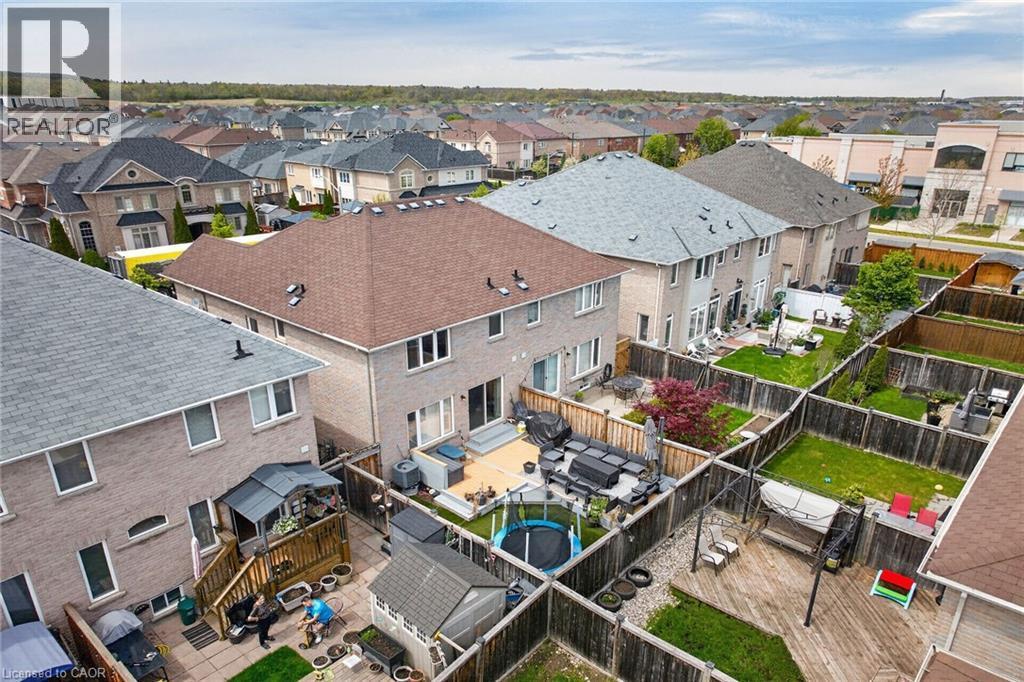 Fenced backyard with a multi-level deck, mature trees, and a ground-level patio - 4236 Prudham Avenue, Burlington, ON - Outdoor