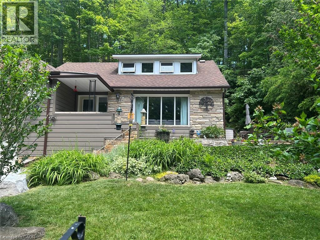 Stone veneer and horizontal siding exterior with a dormer featuring multiple windows - 1333 Hidden Valley Road, Burlington, ON - Outdoor