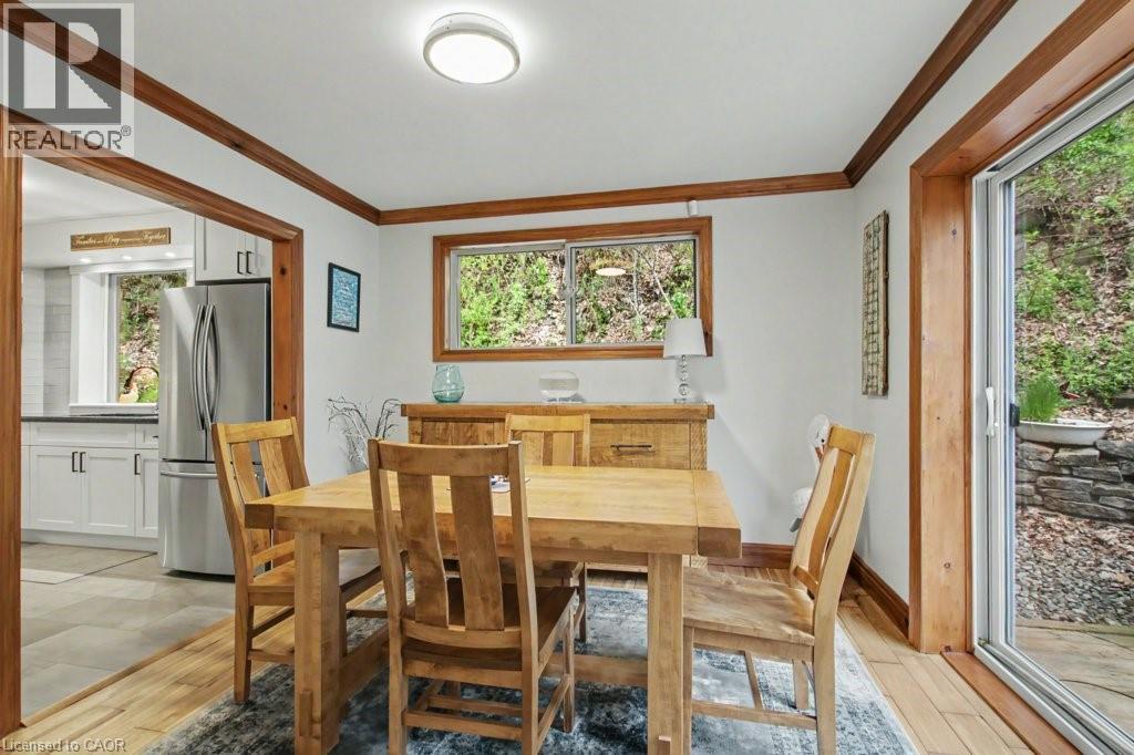 Dining area featuring wood-finish flooring and trim, with a sliding glass door providing outdoor access - 1333 Hidden Valley Road, Burlington, ON - Indoor Photo Showing Dining Room