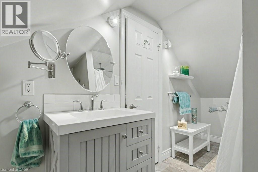 Bathroom featuring a grey vanity with integrated sink, chrome faucet, and overhead lighting - 1333 Hidden Valley Road, Burlington, ON - Indoor