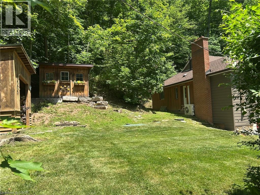 Expansive backyard featuring a manicured lawn, multiple outbuildings, and mature trees - 1333 Hidden Valley Road, Burlington, ON - Outdoor