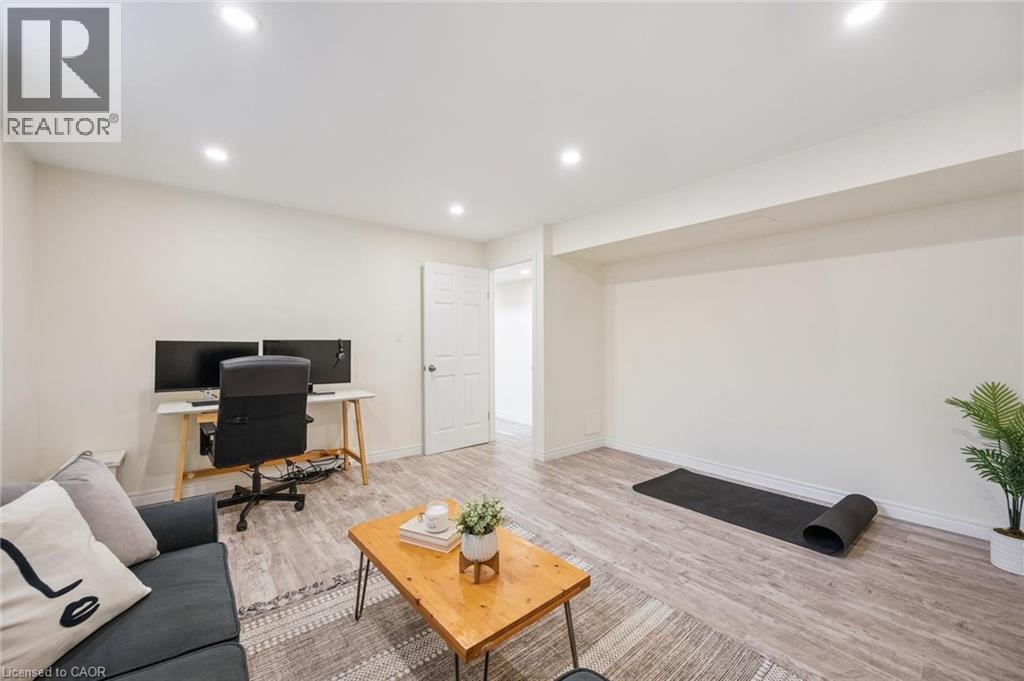 Spacious open-concept room featuring recessed lighting, wood-finish flooring, and crisp white walls - 87 Barbara Crescent, Kitchener, ON - Indoor