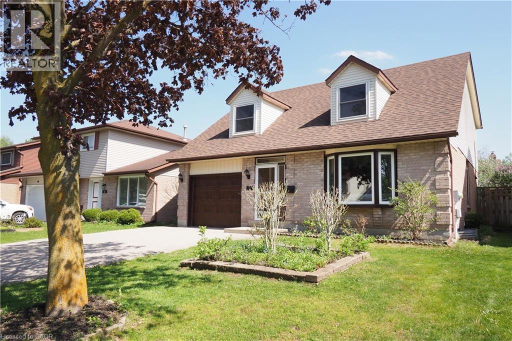 Brick-front residence with a prominent bay window, two dormer windows, a brown shingle roof, and an attached garage with a dark wood-finish door - 27 Scenic Wood Crescent, Kitchener, ON - Outdoor With Facade