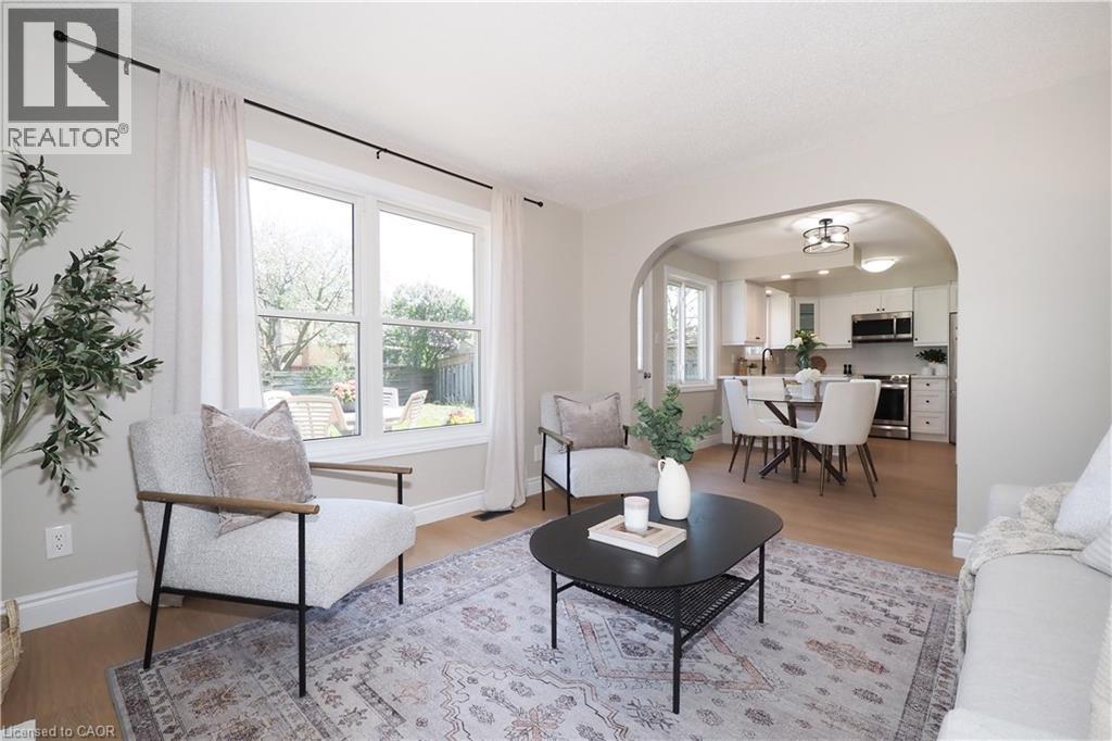 Bright living area with wood-finish flooring, white trim, and light wall paint - 27 Scenic Wood Crescent, Kitchener, ON - Indoor Photo Showing Living Room