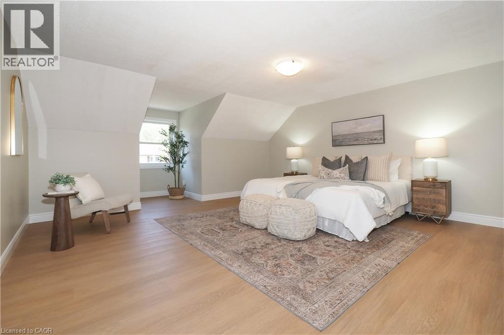 Dormer room featuring wood-finish flooring, light-toned wall paint, white baseboards, and a single window - 27 Scenic Wood Crescent, Kitchener, ON - Indoor Photo Showing Bedroom