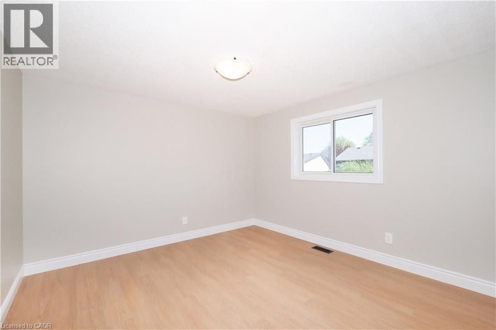 Neutral-toned walls complement wood-finish flooring - 27 Scenic Wood Crescent, Kitchener, ON - Indoor Photo Showing Other Room