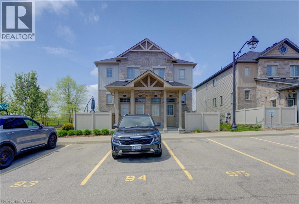 Stone and siding facade featuring a gabled roofline and covered entryway - 388 Old Huron Road Unit# 24A, Kitchener, ON - Outdoor With Facade