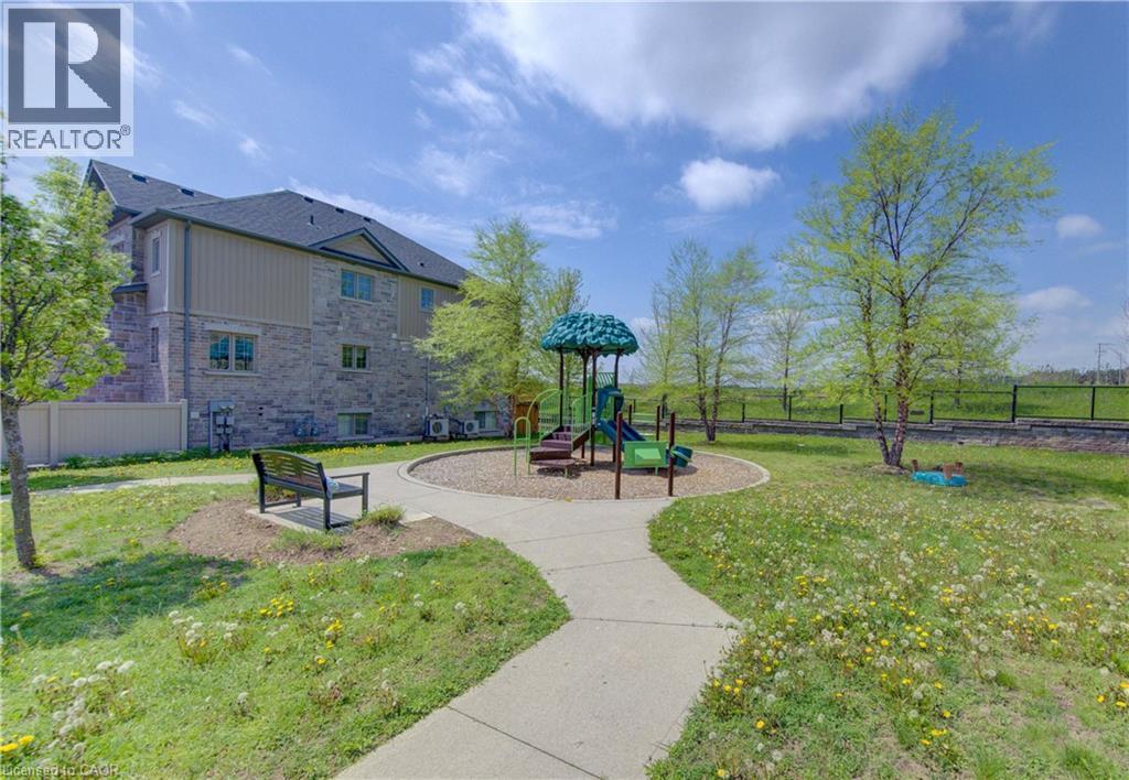 Outdoor play area featuring a slide, climbing structures, and a dedicated bark chip surface - 388 Old Huron Road Unit# 24A, Kitchener, ON - Outdoor