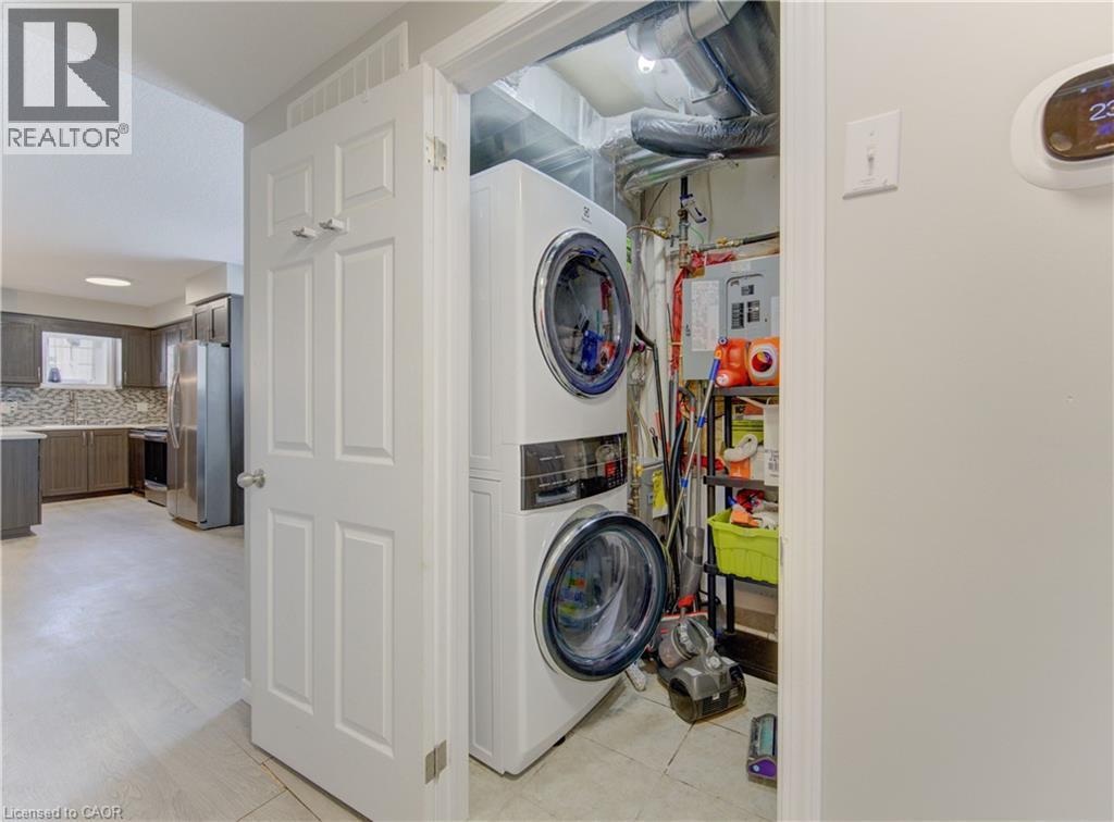 Dedicated laundry closet featuring a stacked washer and dryer unit - 388 Old Huron Road Unit# 24A, Kitchener, ON - Indoor Photo Showing Laundry Room