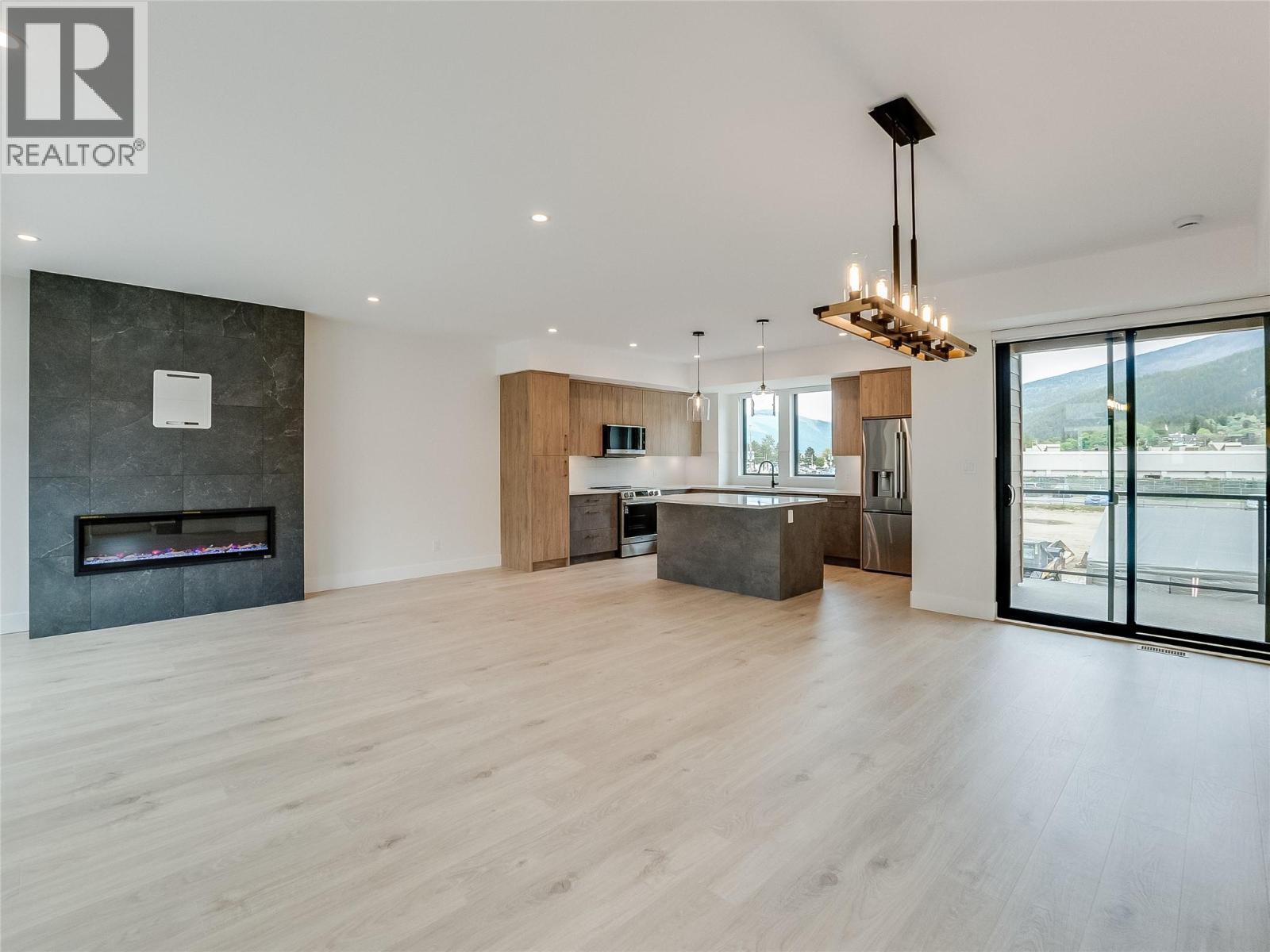 Dining, kitchen, living room all open concept - 910 Lakeside Drive Unit# 208, Nelson, BC - Indoor With Fireplace