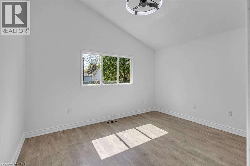 Vaulted ceiling room featuring white walls, light wood-finish flooring, and a modern ceiling fan with integrated lighting - 375 Silverbirch Boulevard, Hamilton, ON - Indoor Photo Showing Other Room