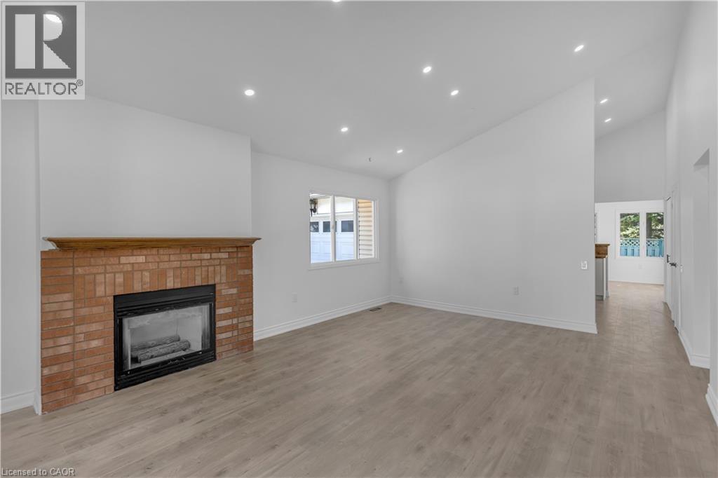Living area featuring a brick fireplace with a wood mantle, recessed lighting, and wood-finish flooring - 375 Silverbirch Boulevard, Hamilton, ON - Indoor With Fireplace